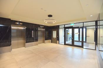 A spacious lobby with marble floors and a ceiling light